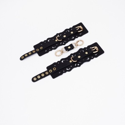 Черные кожаные наручники с узорами и золотистой фурнитурой