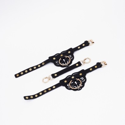 Черные кожаные оковы с резными узорами и клепками